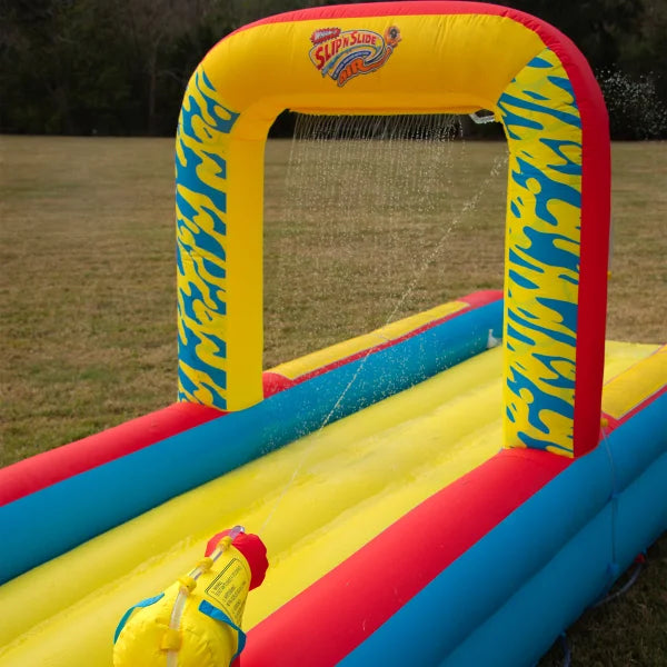 Inflatable Slip 'n Slide water toy with arch and sprayers on a grassy lawn