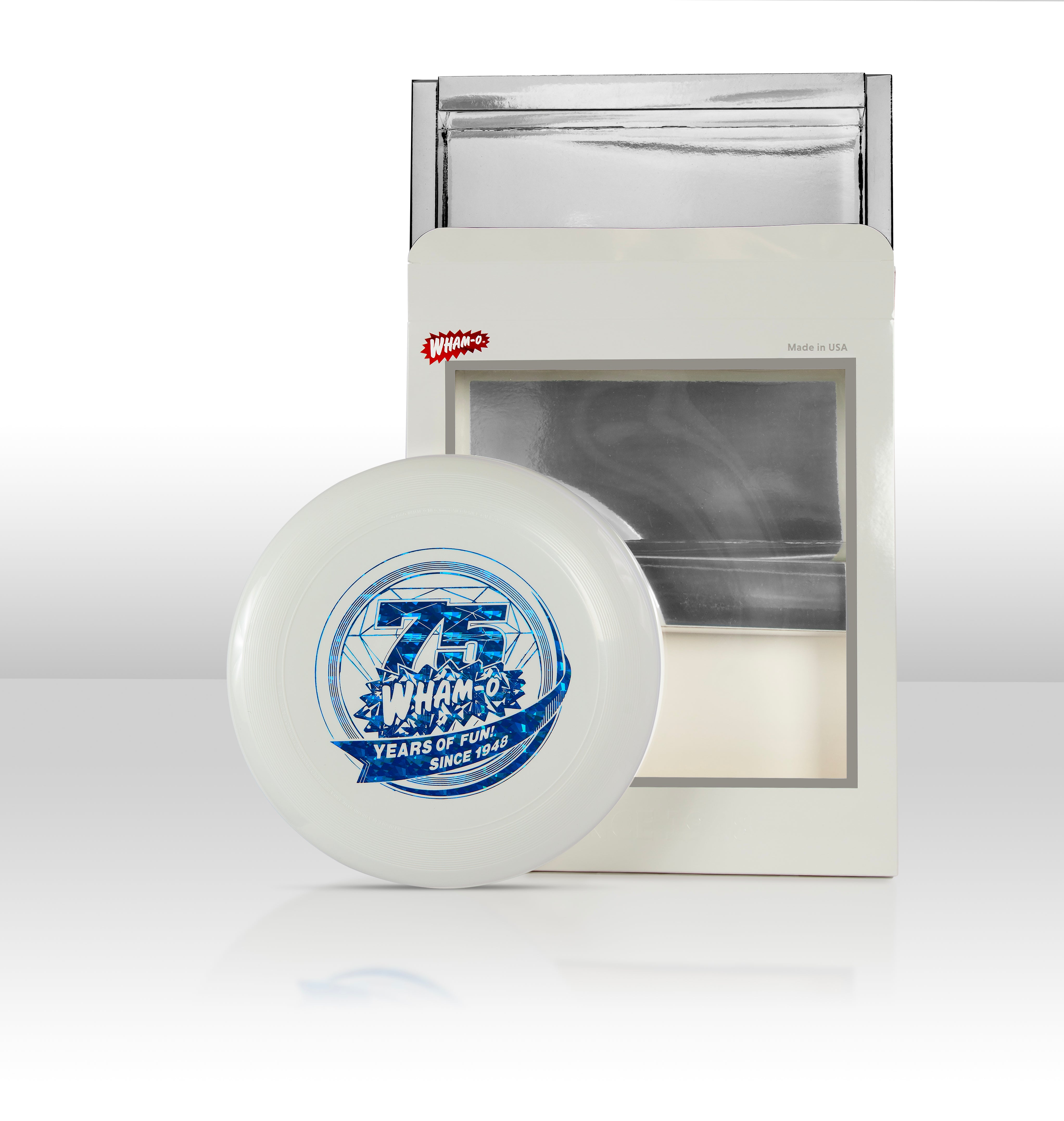 White Frisbee with blue 75th anniversary graphic in front of silver and white packaging