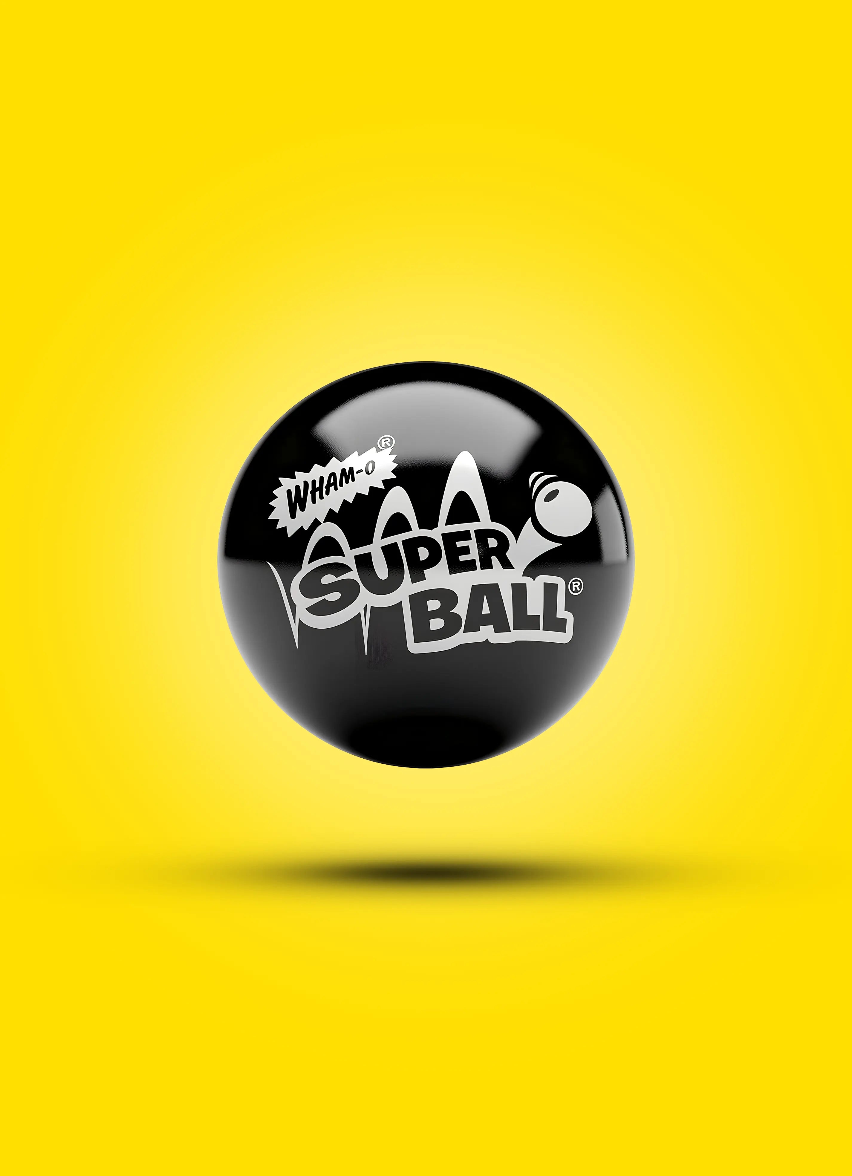 Black Super Ball with white logo floating on a yellow background, classic toy.