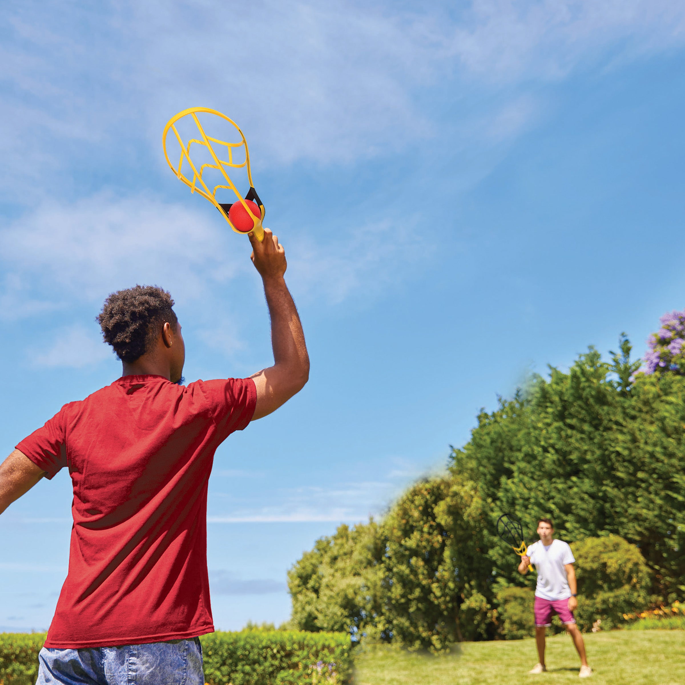 Two brothers are playing with Wham-O Game Time! Trac-Ball® II in the garden