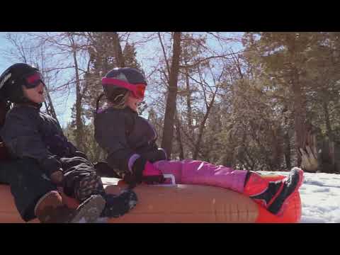 Children are sliding Wham-O Snowboogie® Hot Dog Tube 93"