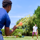 Two men are playing Wham-O Game Time! Trac-Ball® Classic in the garden