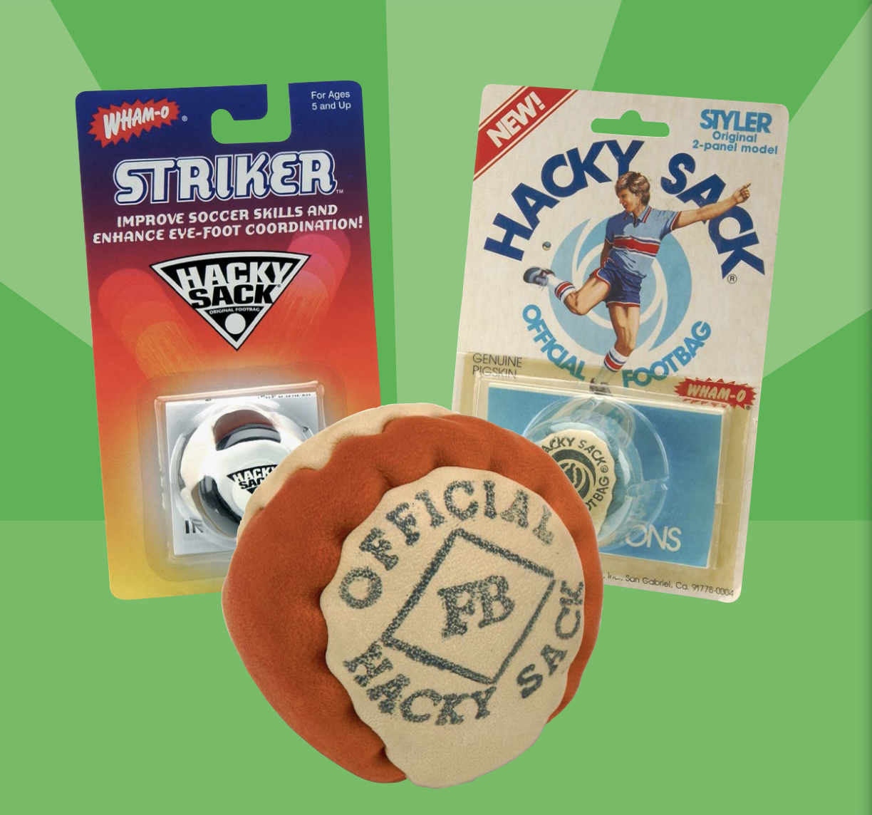 Close-up of official Hacky Sack footbags in retail packaging on green background.