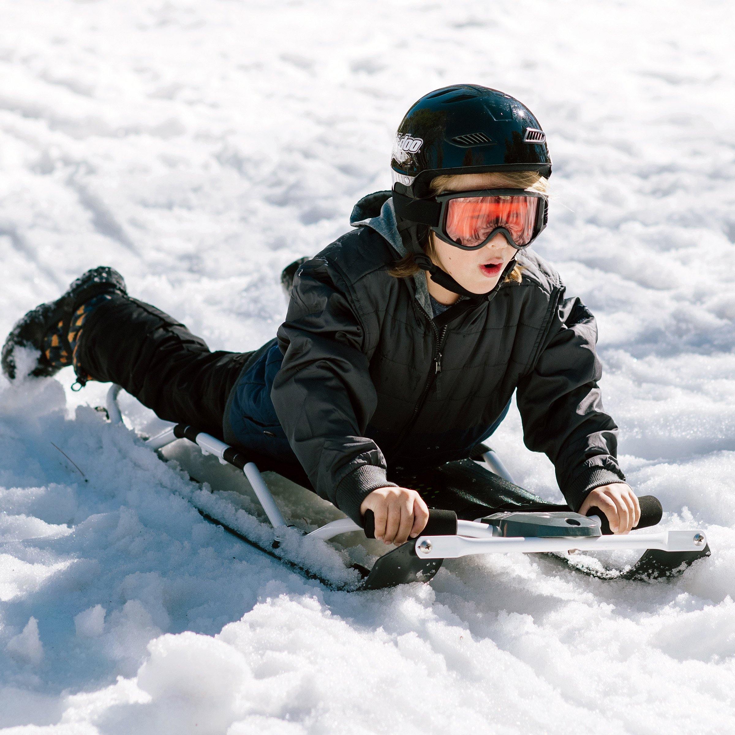 A boy is sliding down the hill with Wham-O Snowboogie® Fantom-X