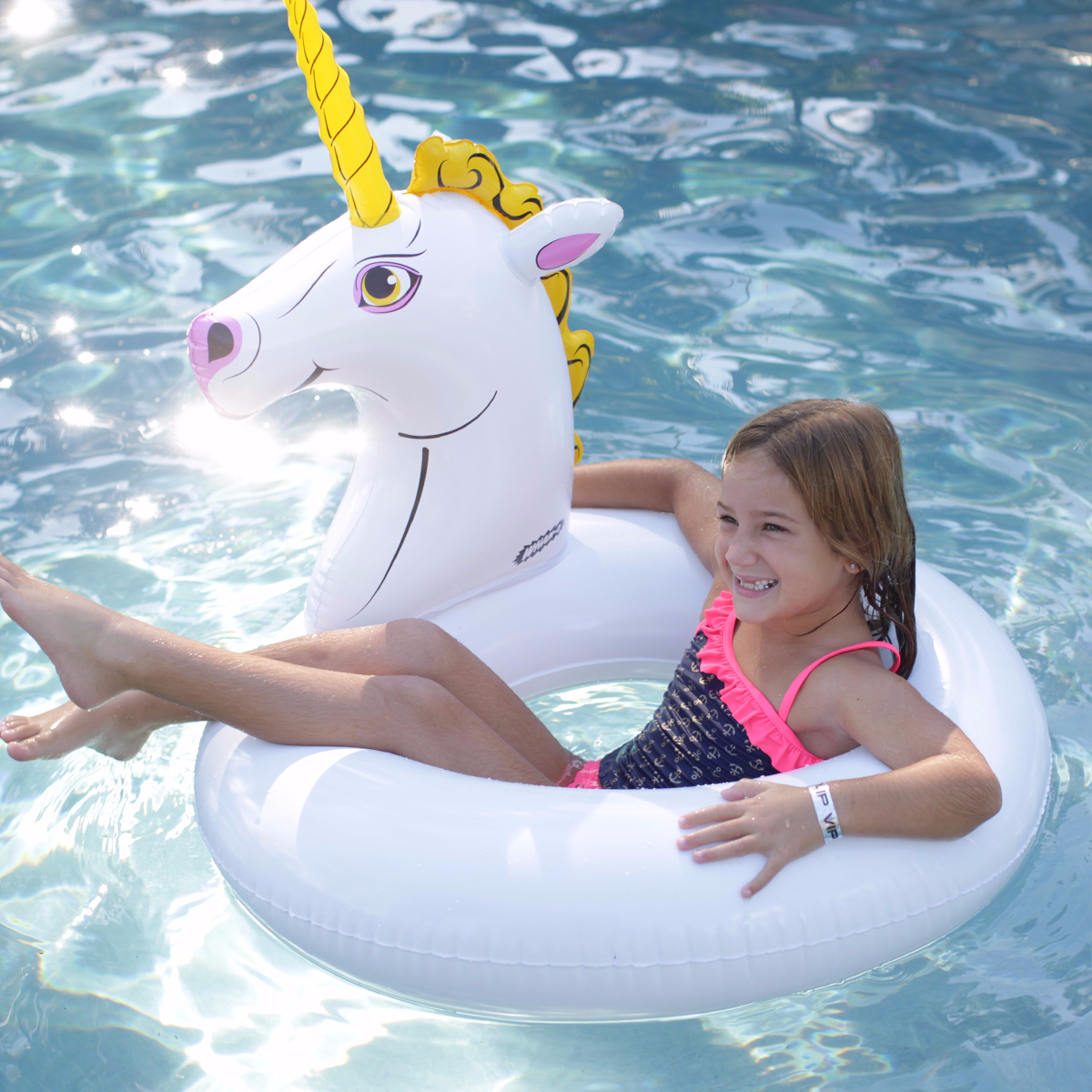 The girl is floating with Wham-O Splash Unicorn Pool Float