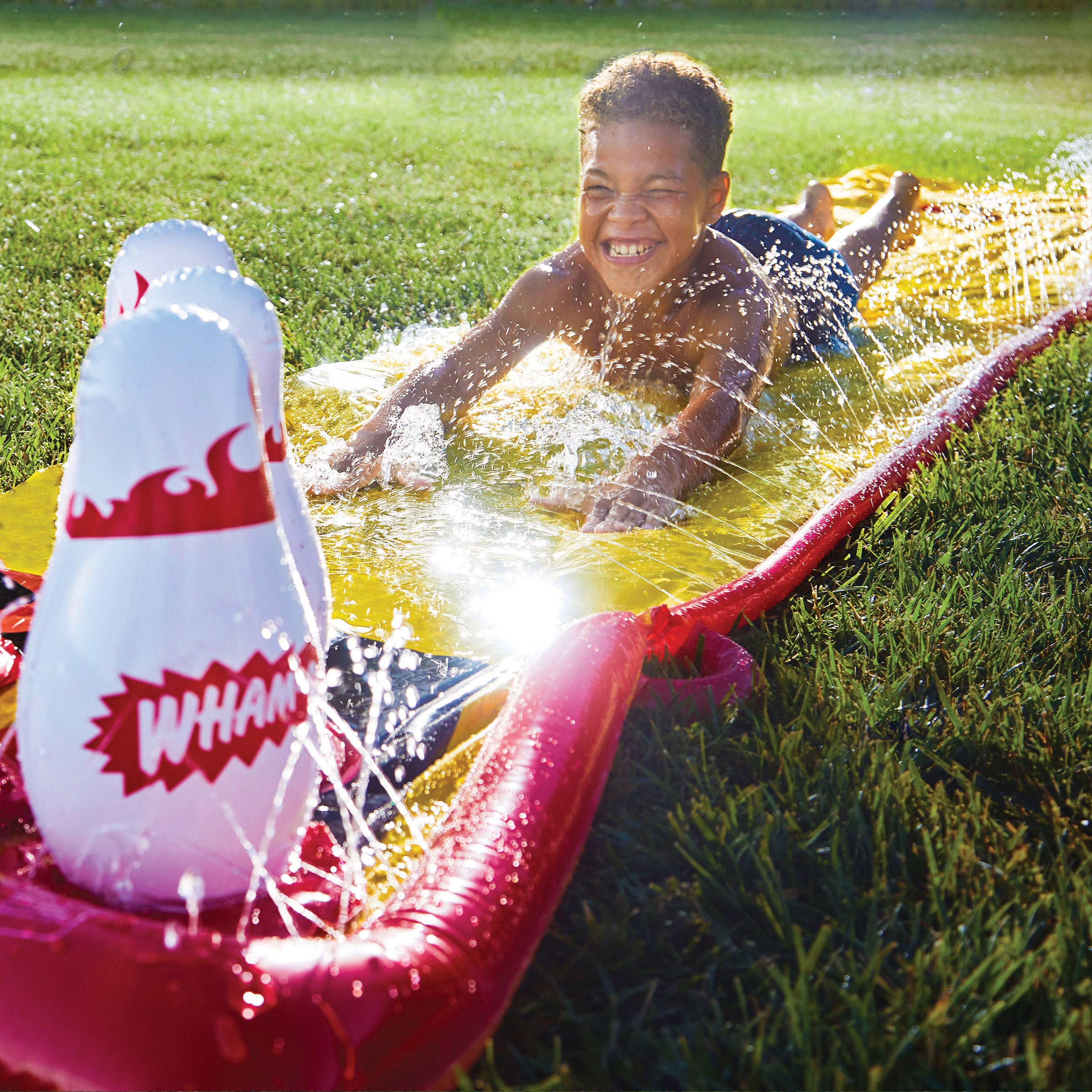 A boy is sliding on Wham-O Splash Bowling