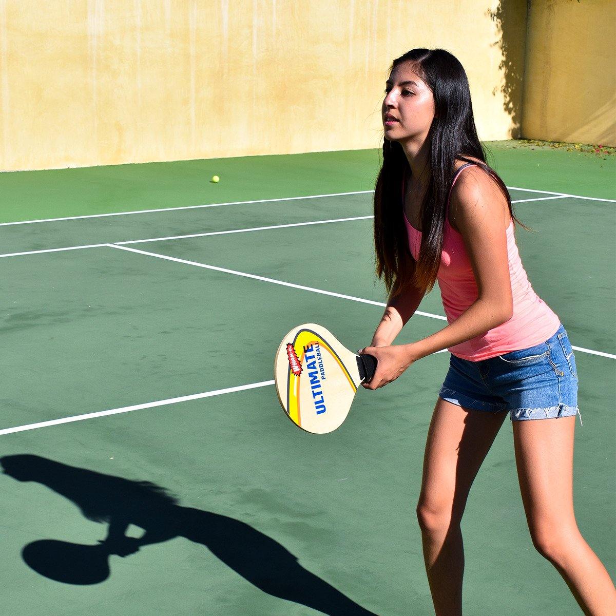 A woman is playing Wham-O Game Time! Ultimate Paddle Ball in the Tennis court