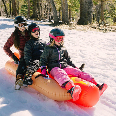 Children are sliding Wham-O Snowboogie® Hot Dog Tube 93"