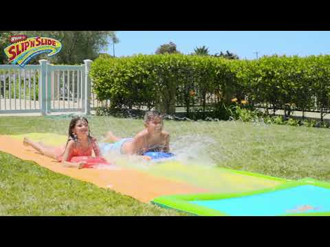 A boy and a girl is having fun with Wham-O Slip 'N Slide® Double Hydroplane XL in the backyard