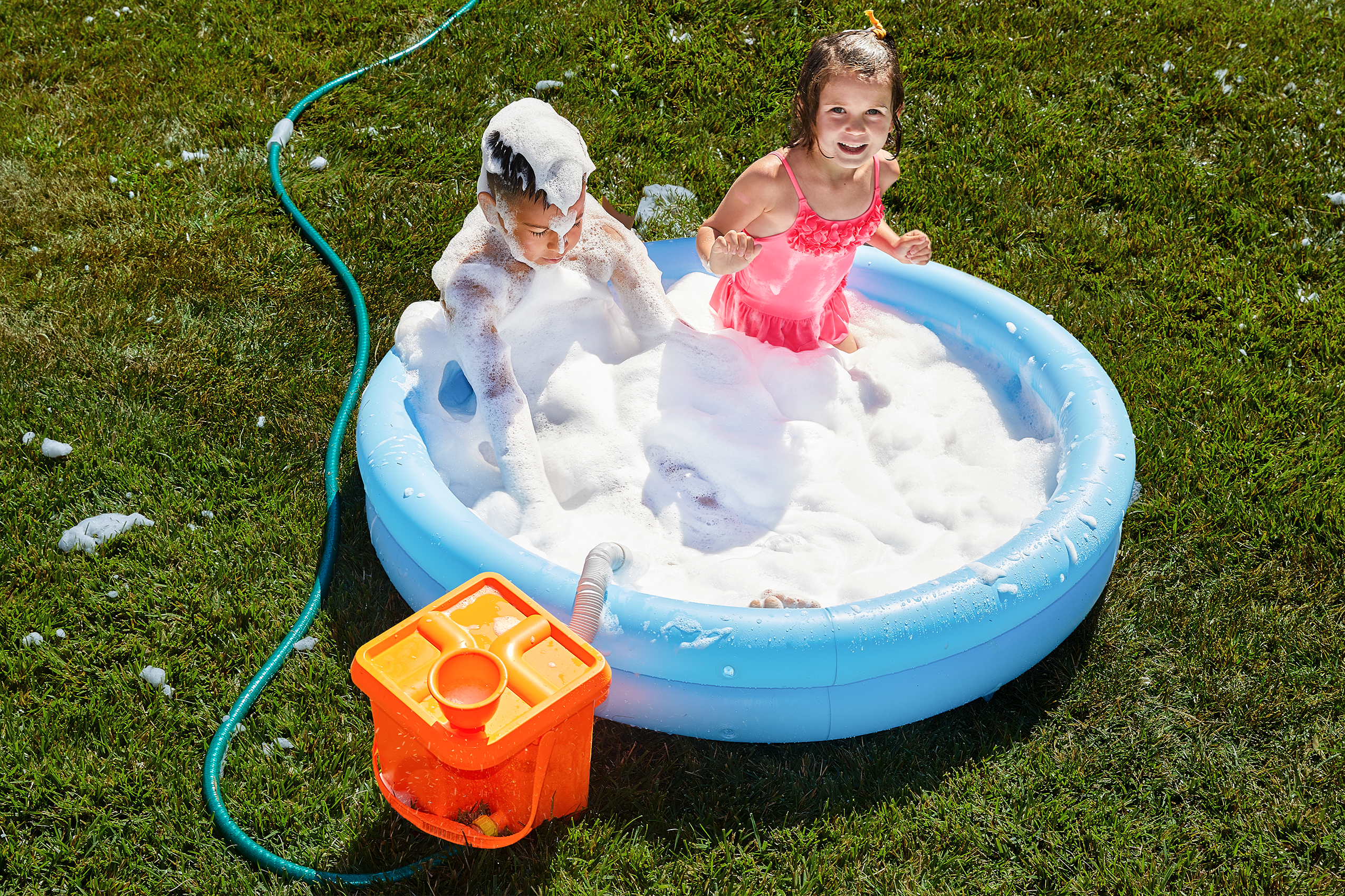 Children are playing with Foam Party™ Bucket With Kiddie Pool in backyard